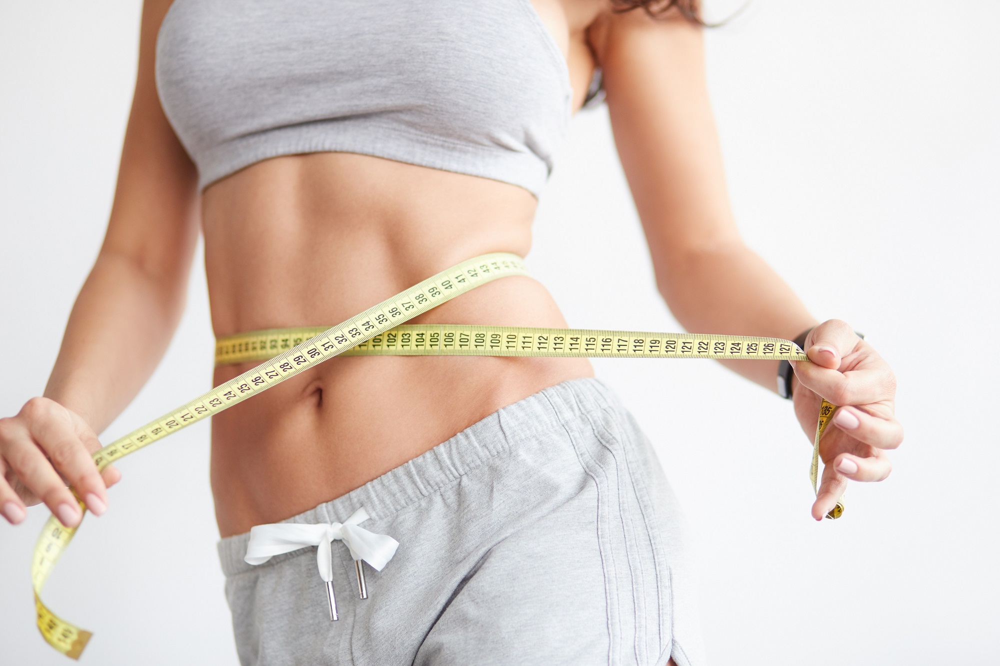 Woman measuring her waistline | Elle Skin & Beauty Co. | Florence, KY